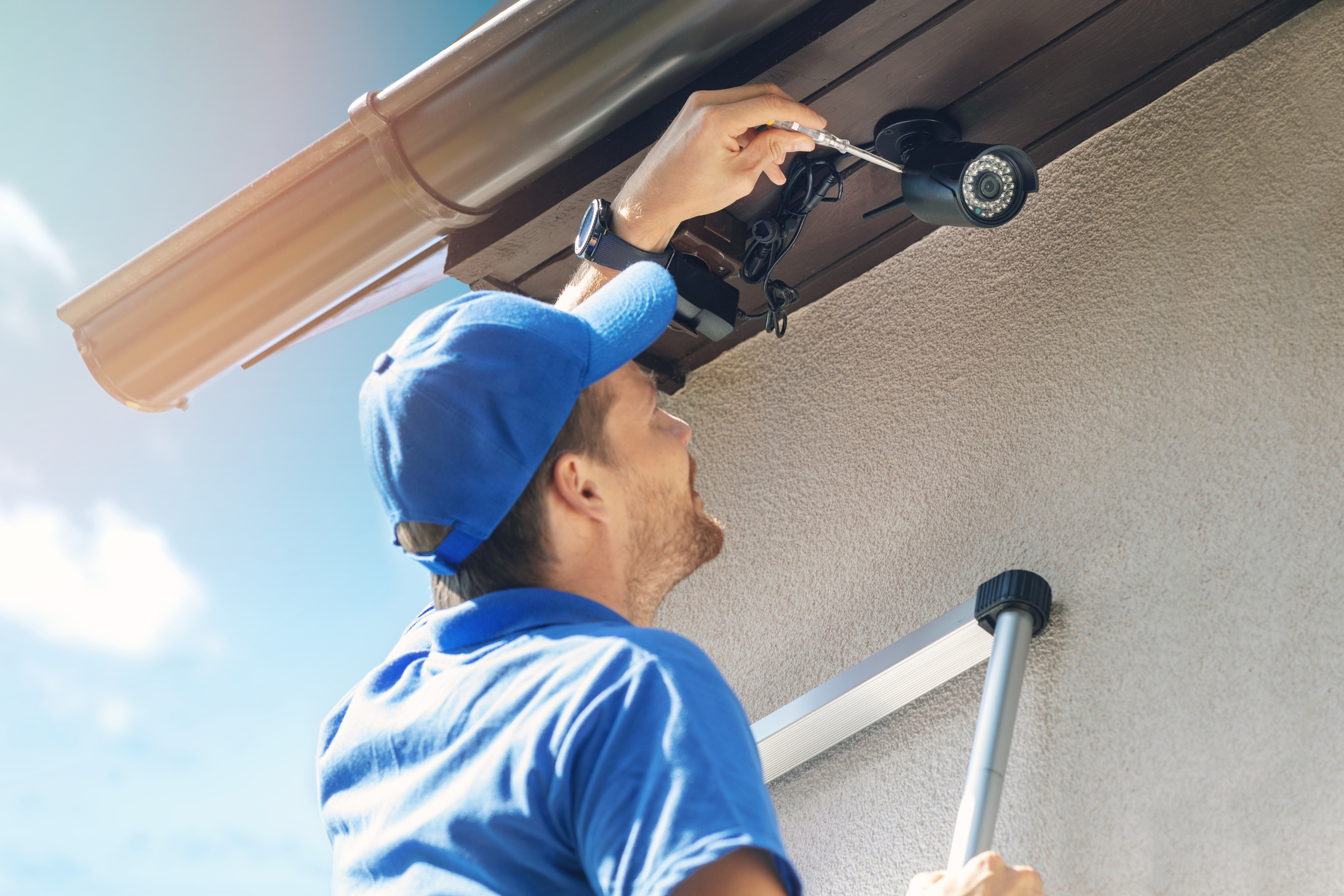 Man installing security camera on home