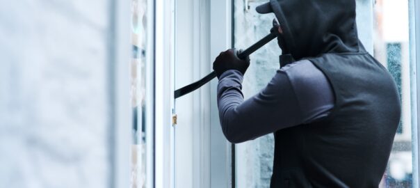 Criminal using crowbar to break into a home.